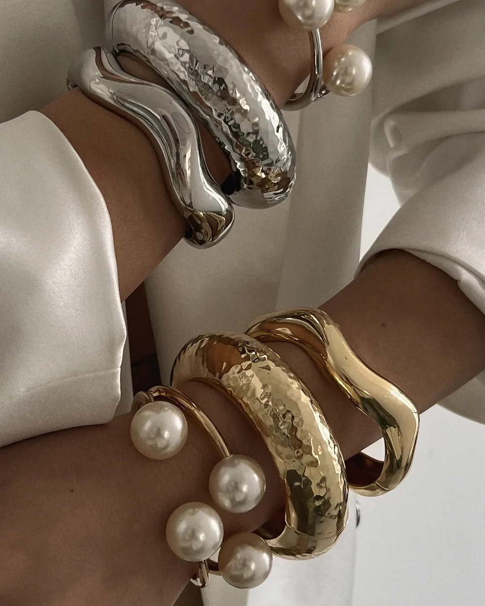 Pearl and gold bracelets worn with a white shirt